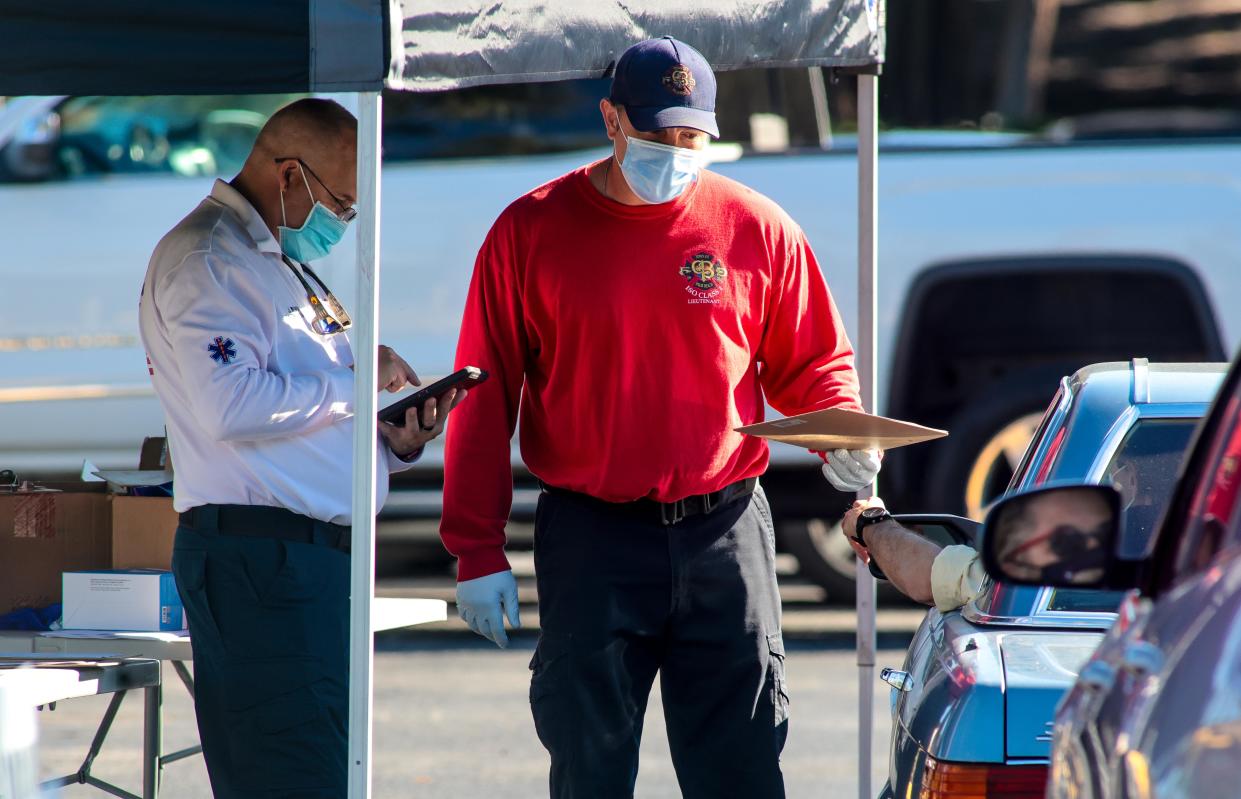 Palm Beach Fire Rescue workers register resident Jan. 6 who came to Phipps Ocean Park to receive COVID-19 rapid antigen testing.