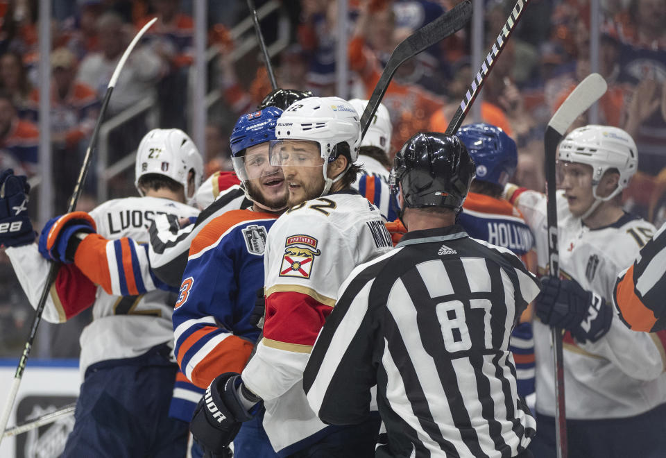 Florida Panthers' Brandon Montour (62) and Edmonton Oilers' Mattias Janmark (13) rough it up during the second period of Game 6 of the NHL hockey Stanley Cup Final, Friday, June 21, 2024, in Edmonton, Alberta. (Jason Franson/The Canadian Press via AP)