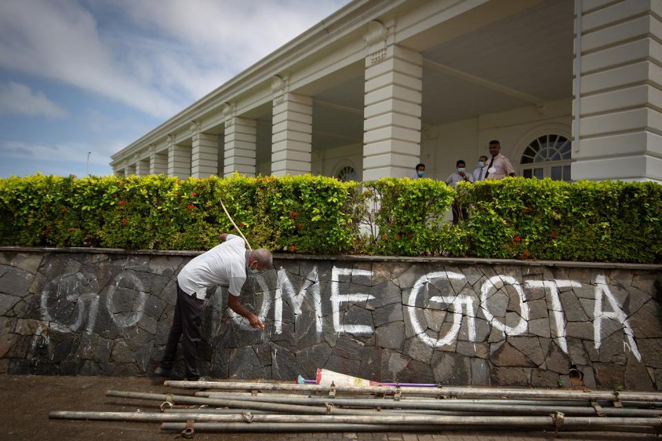 A staff member washes graffiti left behind by protesters. <a href="https://www.gettyimages.com/detail/news-photo/staff-member-washes-graffiti-left-behind-by-protestors-from-news-photo/1409431290?adppopup=true" rel="nofollow noopener" target="_blank" data-ylk="slk:Abhishek Chinnappa/Getty Images;elm:context_link;itc:0;sec:content-canvas" class="link ">Abhishek Chinnappa/Getty Images</a>