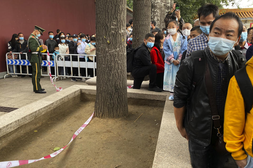 Visitors wearing masks to protect from coronavirus line up for security checks to enter the Tiananmen area during National Day in Beijing on Thursday, Oct. 1, 2020. Millions of Chinese tourists usually would use their week-long National Day holidays to travel abroad. This year, travel restrictions due to the coronavirus pandemic mean that some 600 million tourists - about 40% of the population - will travel within China during the holiday that began Thursday, according to Ctrip, China's largest online travel agency. (AP Photo/Ng Han Guan)