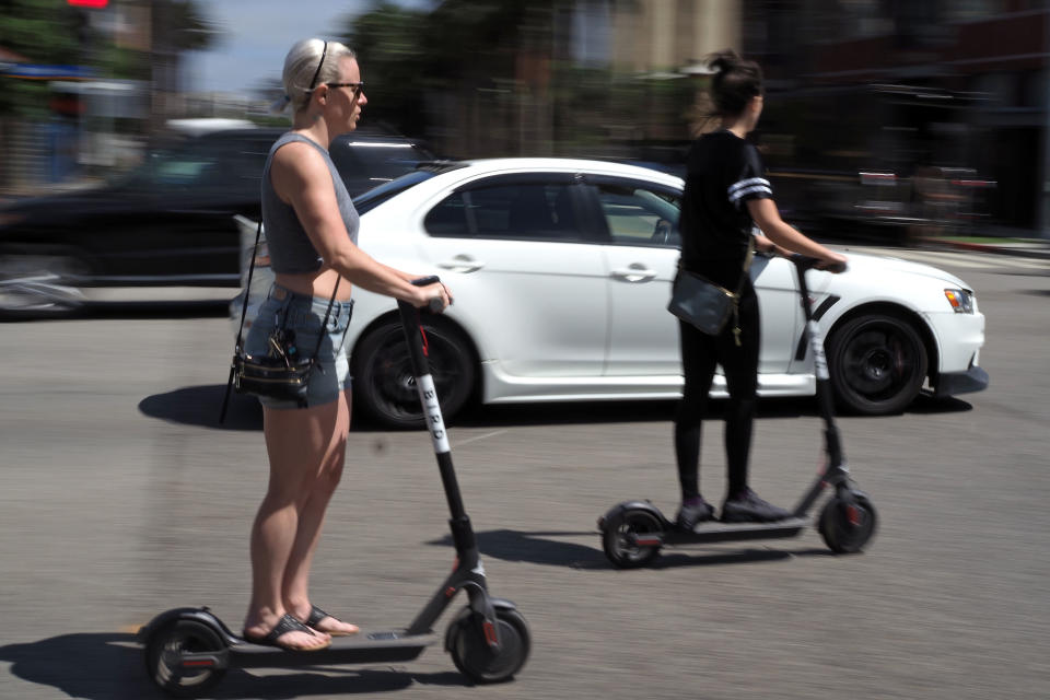 People ride shared electric scooters in Santa Monica, California, on July 13, 2018. (Photo: ROBYN BECK/AFP/Getty Images)