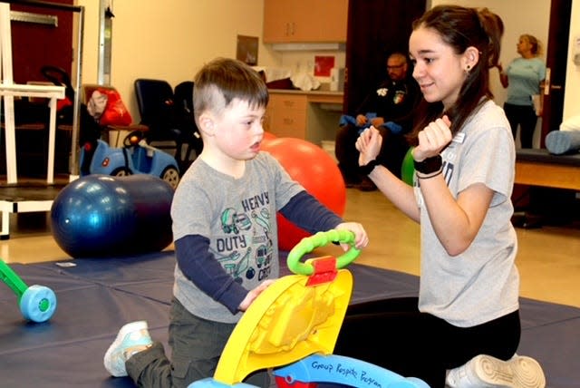 URI nursing student Emily Nichols works with 4-year-old Asher in Independence Square on a recent Saturday afternoon during the respite care program.