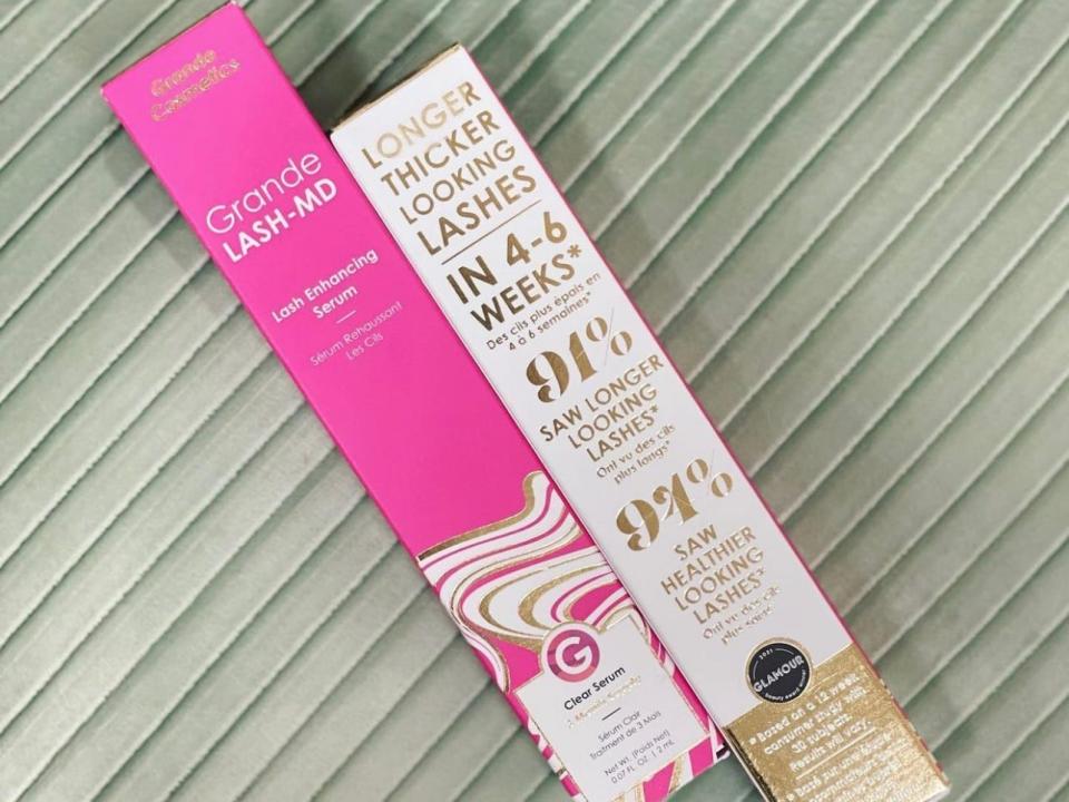 A pink box with "Grande Lash MD" text and a white box with gold writing saying "longer thicker looking lashes in 4-6 weeks" and other product details against a green background