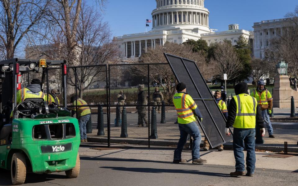  Workers build a fence around the Capitol - John Moore /Getty