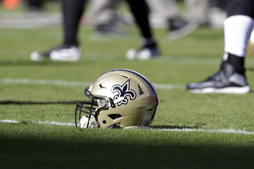 FILE - In this Oct. 23, 2016, file photo, a New Orleans Saints helmet rests on the playing field before an NFL football game in Kansas City, Mo. An Associated Press review of public tax documents found that the Bensons' foundation has given at least $62 million to the Archdiocese of New Orleans and other Catholic causes over the past dozen years, including gifts to schools, universities, charities and individual parishes. (AP Photo/Jeff Roberson, File)