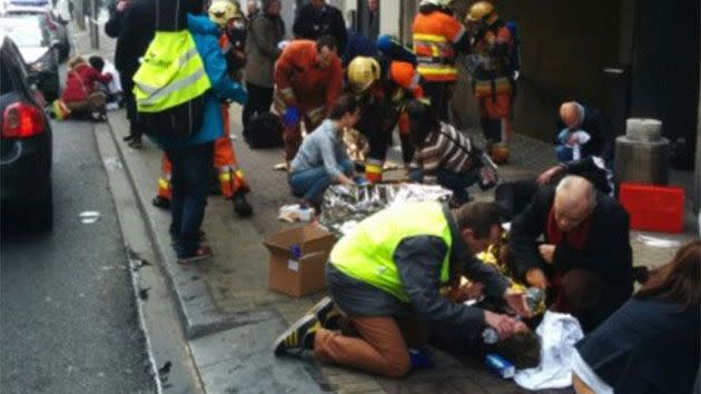 Wounded survivors are treated by others on the footpath outside the train station. Photo: Twitter