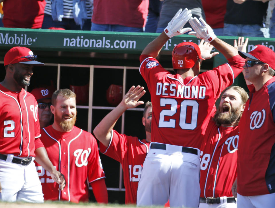 Washington Nationals' Ian Desmond (20) celebrates with Jayson Werth, second from right, and other teammates after hitting a game-winning solo home run during the seventh inning of a baseball game against the Atlanta Braves at Nationals Park, Sunday, April 6, 2014, in Washington. The Nationals won 2-1. (AP Photo/Alex Brandon)