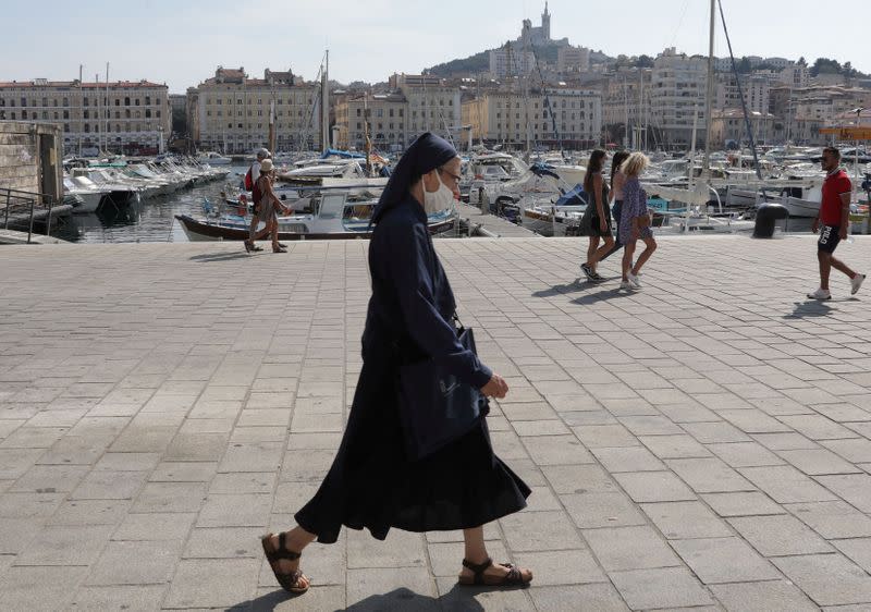 FILE PHOTO: A nun wearing a protective face mask walks at the Old Port in Marseille