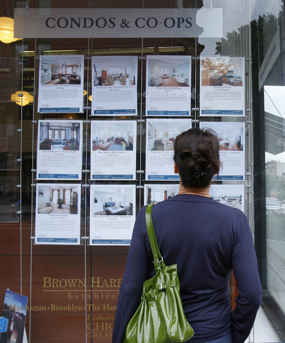 A customer looks at listings on display outside a Brown Harris Stevens offices in New York. (Credit: Brendan McDermid, REUTERS)