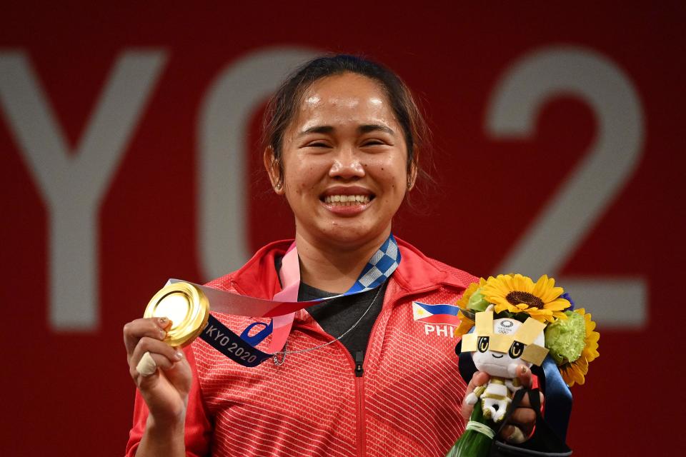 The Philippines' weightlifter Hidilyn Diaz stands on the podium with her women's 55kg gold medal at the Tokyo Olympics.