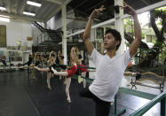 In this photo taken Nov. 25, 2012, Filipino slum dweller Jamil Montebon, right, focuses during a class at Ballet Manila at the Philippine capital. Montebon, a scholar at Ballet Manila's program, used to collect garbage and also worked at a junk shop. He now receives a monthly stipend, stays at their dormitory and given meals. (AP Photo/Aaron Favila)