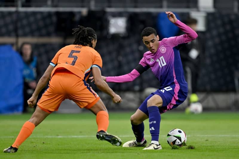 The Netherlands' Nathan Ake (L) and Germany's Jamal Musiala battle for the ball during the International Friendly soccer match between Germany and Netherlands at the Deutsche Bank Park stadium. Arne Dedert/dpa