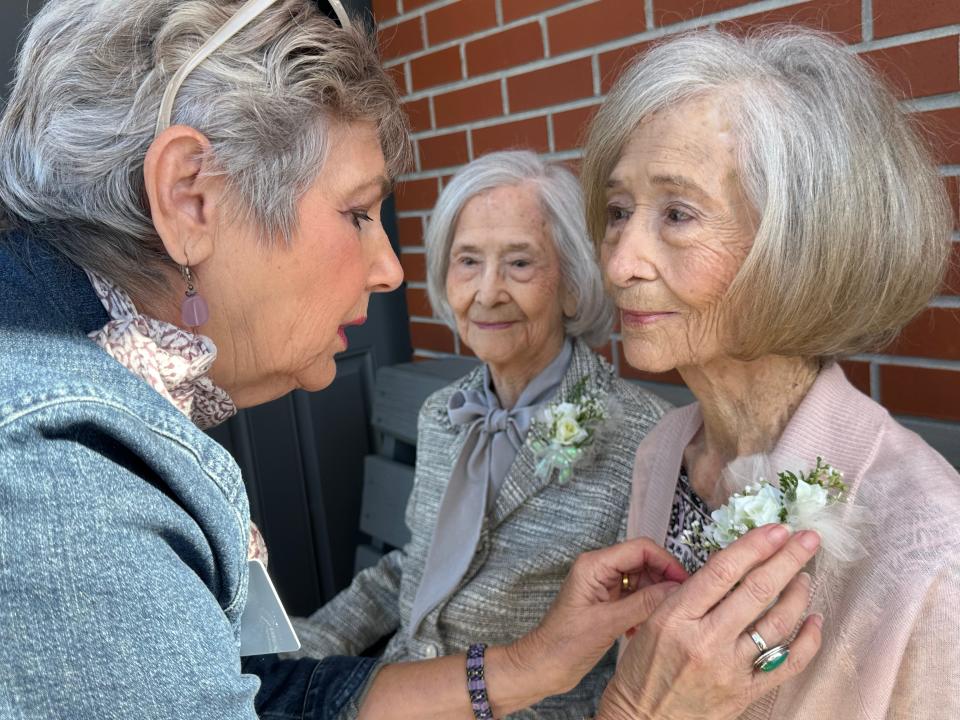 Sue Meyer of the Garden Club pins a flower on Vera Herring Rozier before they went in for the 100 birthday celebration.