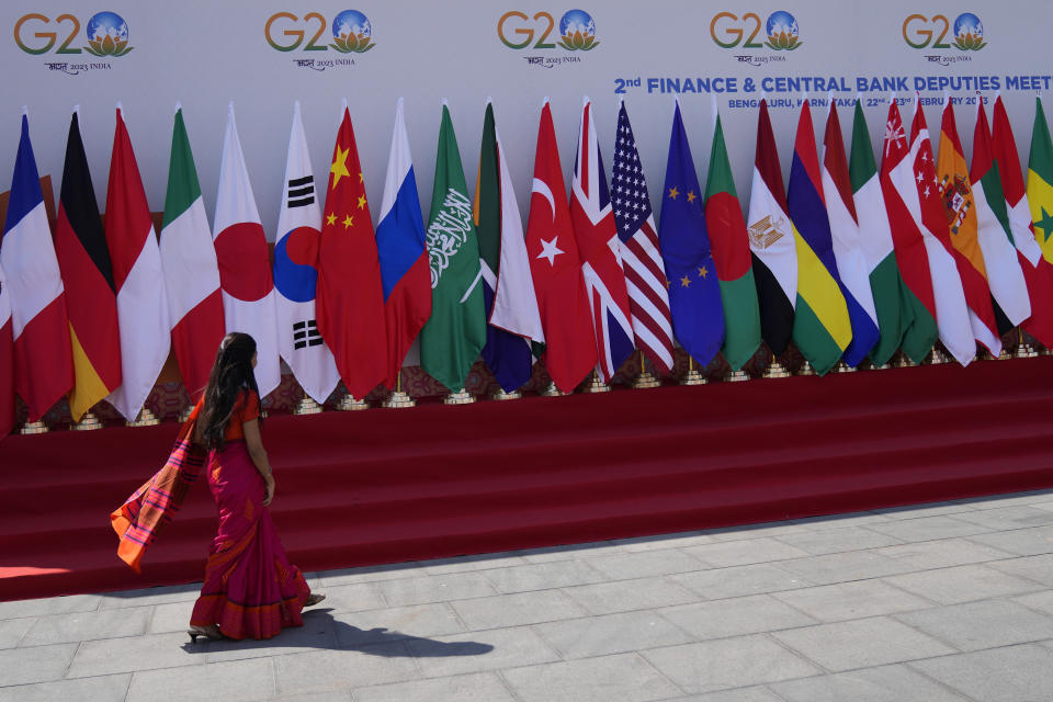 A delegate walks past a display of flags of participating countries at the venue of G-20 financial conclave on the outskirts of Bengaluru, India, Wednesday, Feb. 22, 2023. Top financial leaders from the Group of 20 leading economies are gathering in the south Indian technology hub of Bengaluru to tackle challenges to global growth and stability. India is hosting the G-20 financial conclave for the first time in 20 years. (AP Photo/Aijaz Rahi)