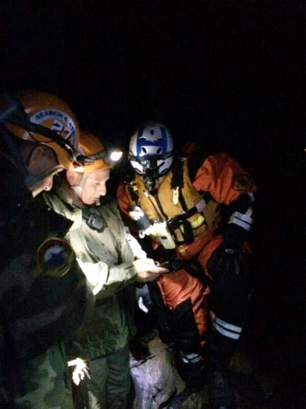 In this photo provided by the Los Angeles Sheriff's Department, Malibu Search and Rescue Team members assist four stranded hikers who were trapped overnight March 1, 2014 in a remote area of Malibu Creek State Park, Calif. Although the initial rescue area was inaccessible, the helicopter was finally able to connect with rescuers shortly after 3 a.m. and airlift the hikers to safety.(AP Photo/Los Angeles Sheriff's Department)