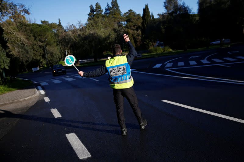 A police officer stops a car at a checkpoint for control on the first day of the second national lockdown due to the coronavirus disease (COVID-19) pandemic in Lisbon