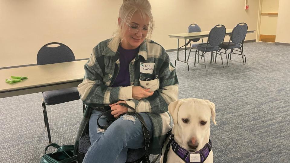 Yellow Labrador Vinnie and his handler Lisa Bronikowski await on Feb. 16, 2023 at the East Lansing Hannah Community Center to greet and help those affected by the recent mass shooting at Michigan State University.