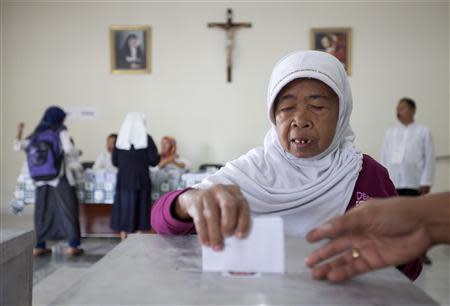 A Muslim woman casts her ballot at a polling station in a Catholic hospital in Yogyakarta April 9, 2014. REUTERS/Dwi Oblo