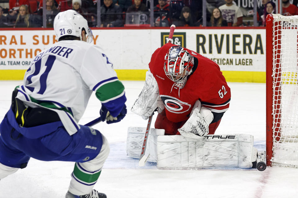 Carolina Hurricanes goaltender Pyotr Kochetkov (52) blocks the shot of Vancouver Canucks' Nils Hoglander (21) during the first period of an NHL hockey game in Raleigh, N.C., Tuesday, Feb. 6, 2024. (AP Photo/Karl B DeBlaker)