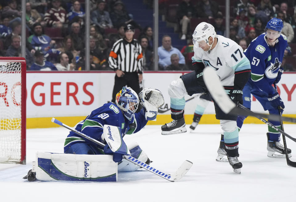 Vancouver Canucks goalie Collin Delia (60) makes a save as Seattle Kraken's Jaden Schwartz (17) and Canucks' Tyler Myers (57) watch during the second period of an NHL hockey game Tuesday, April 4, 2023, in Vancouver, British Columbia. (Darryl Dyck/The Canadian Press via AP)