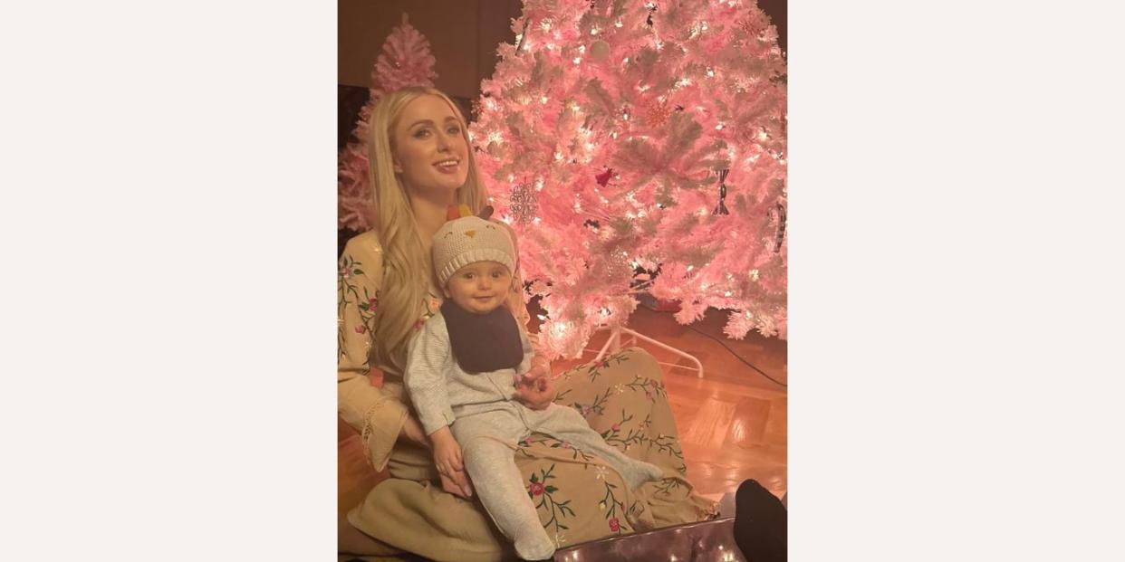 Paris Hilton and son posing with pink Christmas tree