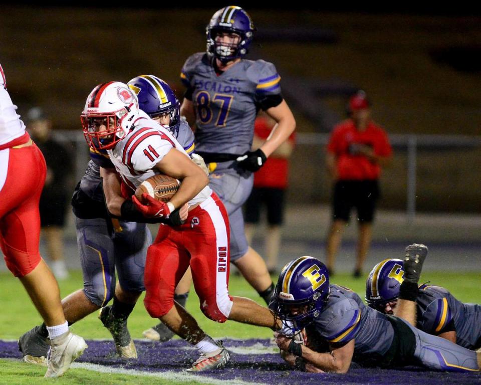 Ripon running back Eric Guevera (11) tries to escape multiple Escalon defenders during a game between Escalon High School and Ripon High School in Escalon, California on October 20, 2023. 