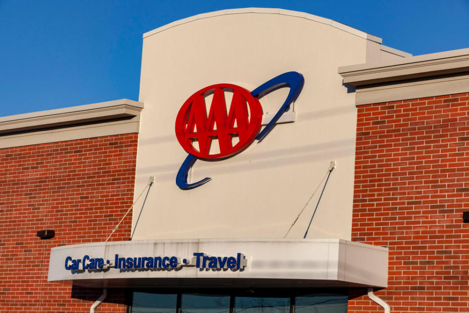 Exterior view of a AAA (American Automobile Association) brick building with the AAA logo and the words "Car Care, Insurance, Travel" displayed on the facade