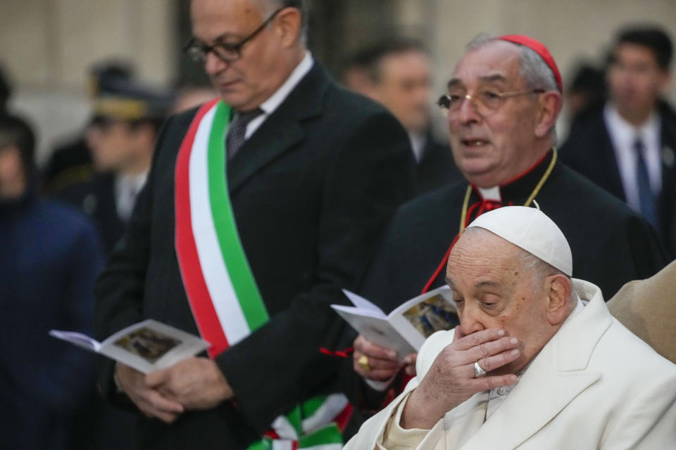 Pope Francis, right, is flanked by, from right, his vicar Cardinal Angelo Comastri, and Rome's Mayor Roberto Gualtieri during his annual Christmas visit to venerate a statue of the Virgin Mary near the Spanish Steps in Rome, Friday, Dec. 8, 2023. (AP Photo/Gregorio Borgia)