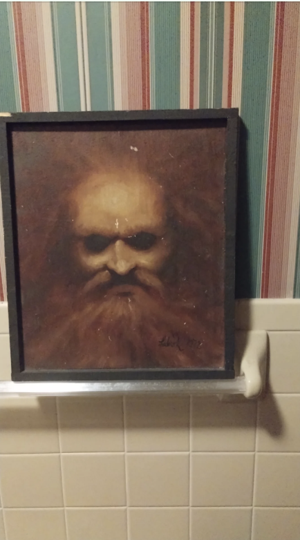 Painting of a bearded figure on a striped wallpaper background, displayed above a white towel rack