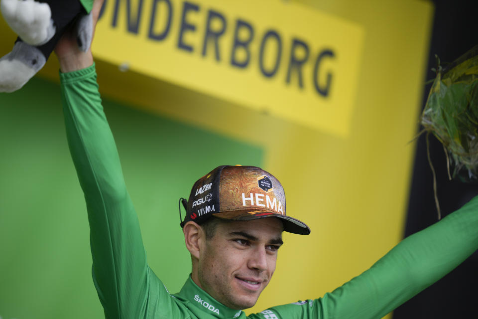Belgium's Wout Van Aert, wearing the best sprinter's green jersey, celebrates on the podium after the third stage of the Tour de France cycling race over 182 kilometers (113 miles) with start in Vejle and finish in Sonderborg, Denmark, Sunday, July 3, 2022. (AP Photo/Daniel Cole)