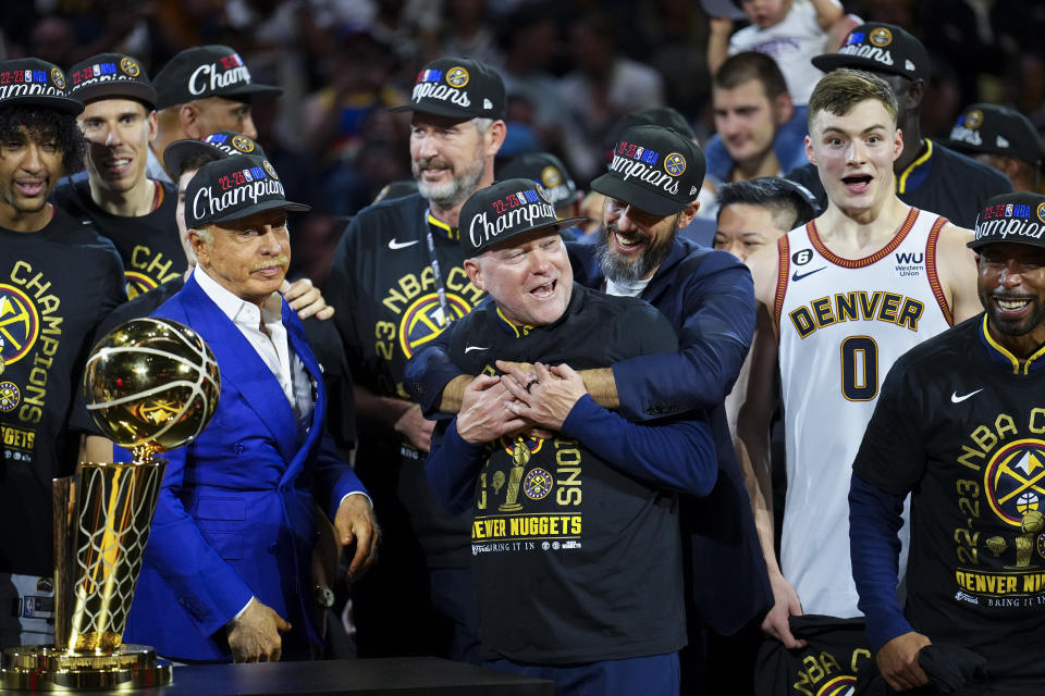 Denver Nuggets owner Josh Kroenke, center right, hugs head coach Michael Malone after the team won the NBA Championship with a victory over the Miami Heat in Game 5 of basketball's NBA Finals, Monday, June 12, 2023, in Denver. (AP Photo/Jack Dempsey)