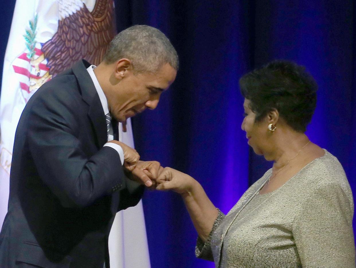 President Barack Obama fist bumps with Aretha Franklin, who sang during a farewell ceremony for Attorney General Eric Holder at the Justice Department on Feb. 27, 2015 in Washington, DC.