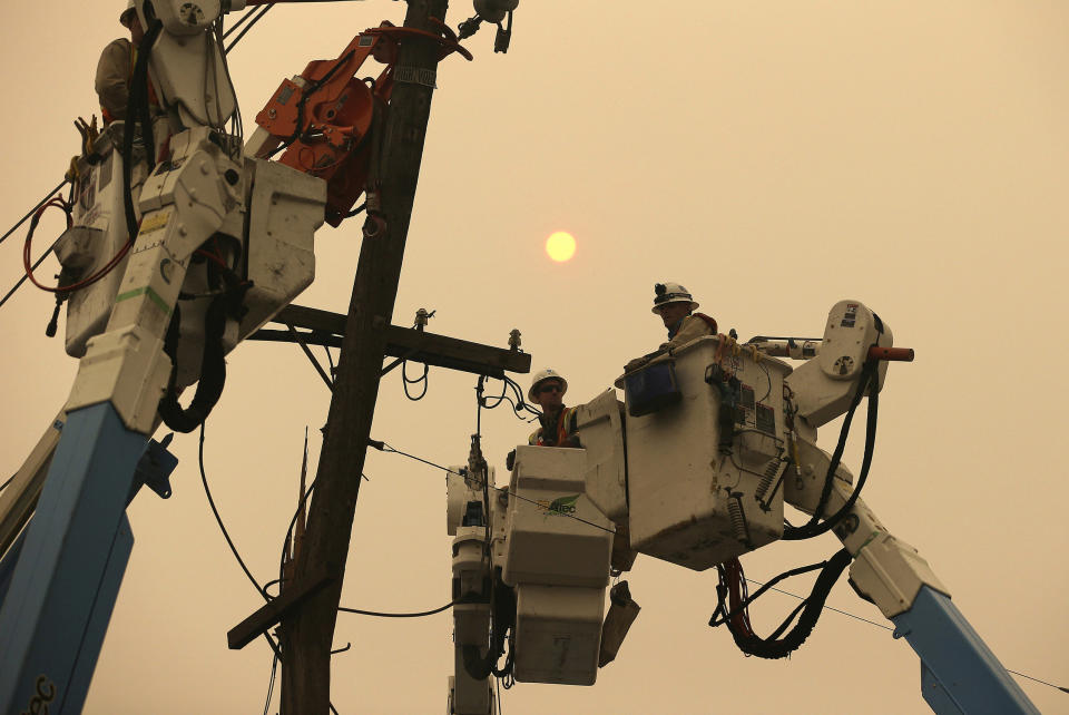 FILE - In this Nov. 9, 2018 file photo, Pacific Gas & Electric crews work to restore power lines in Paradise, Calif. Authorities say power outages have started Wednesday, Oct. 23, 2019, in Northern California after the state's largest utility said it was planning a widespread blackout citing wildfire danger. The Santa Rosa Fire Department tweeted Wednesday that shutoffs had started in the city and it was getting multiple reports of outages. Pacific Gas & Electric said earlier Wednesday it was going forward with blackouts later in the day that could affect 450,000 people in 17 counties of Northern California. (AP Photo/Rich Pedroncelli, File)
