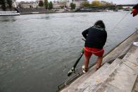 Employees of bicycle sharing service Lime fish an abandoned electric scooter Lime-S out of the River Seine in Paris