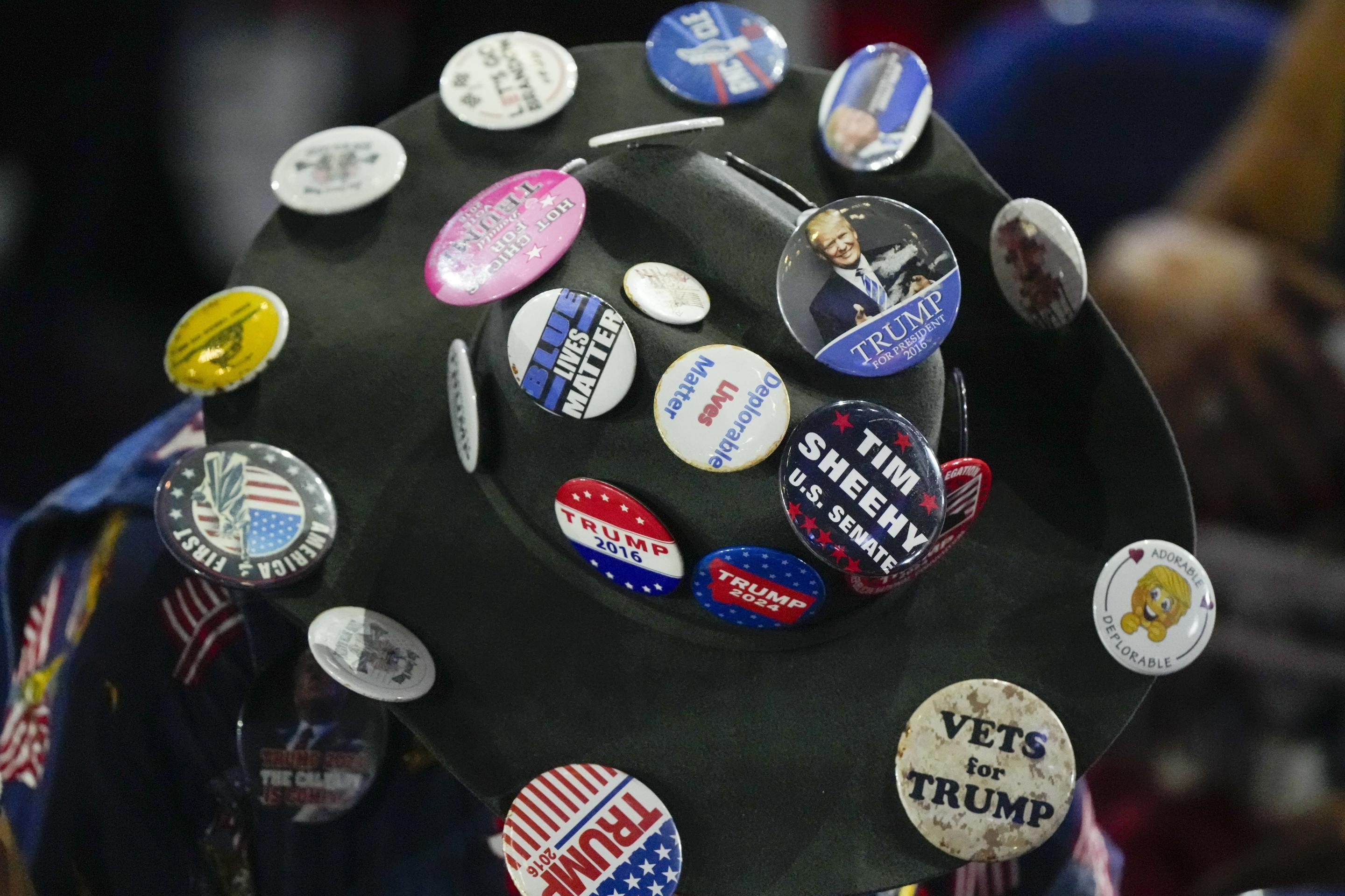 A delegate wears a hat covered in buttons. 