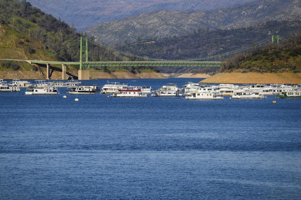 Houseboats float near Lake Oroville’s Bidwell Bar Bridge at on Sunday, March 26 2023, in Butte County, Calif. Months of winter storms have replenished California’s key reservoirs after three years of punishing drought. (AP Photo/Noah Berger)