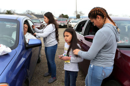 Violet Orozco (2nd R), 9, has her hair brushed by her sister Bertha (R), of Gridley, California, at a Red Cross relief center in Chico, California, after an evacuation was ordered for communities downstream from the Lake Oroville Dam, in Oroville, California, U.S. February 13, 2017. REUTERS/Beck Diefenbach