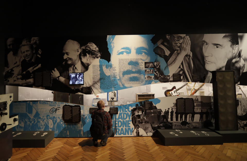 In this picture taken on Tuesday, Nov. 12, 2019, a visitor views the exhibition "The Technology in Dictatorships," at the National technical Museum in Prague, Czech Republic. The exhibition, the first of that kind here, marks the 30th anniversary of the 1989 anti-communist Velvet Revolution by looking back at the surreal repression of a nation and resistance against it. (AP Photo/Petr David Josek)