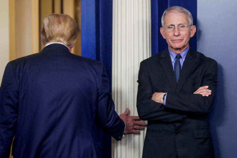 President Donald Trump is seen following a coronavirus task force daily briefing in March as Fauci stands by. (Photo: Jonathan Ernst/Reuters)