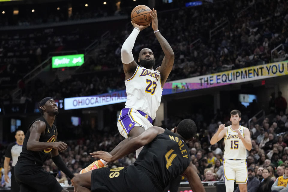 Los Angeles Lakers forward LeBron James (23) shoots over Cleveland Cavaliers forward Evan Mobley (4) during the first half of an NBA basketball game Saturday, Nov. 25, 2023, in Cleveland. (AP Photo/Sue Ogrocki)