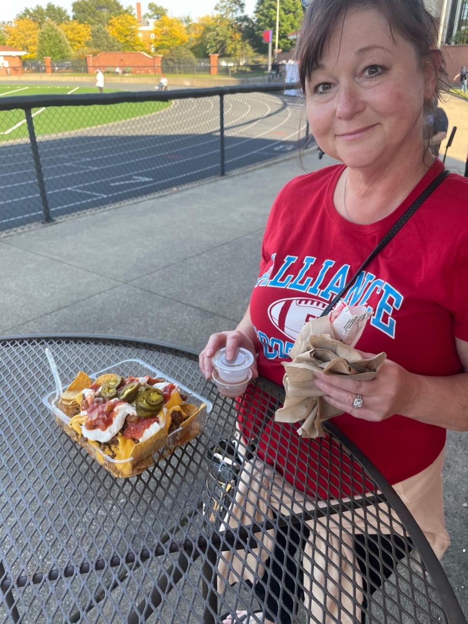 Alliance football mom Tammy Fisher eats dinner before her son's game at Kehres Stadium at University of Mount Union.