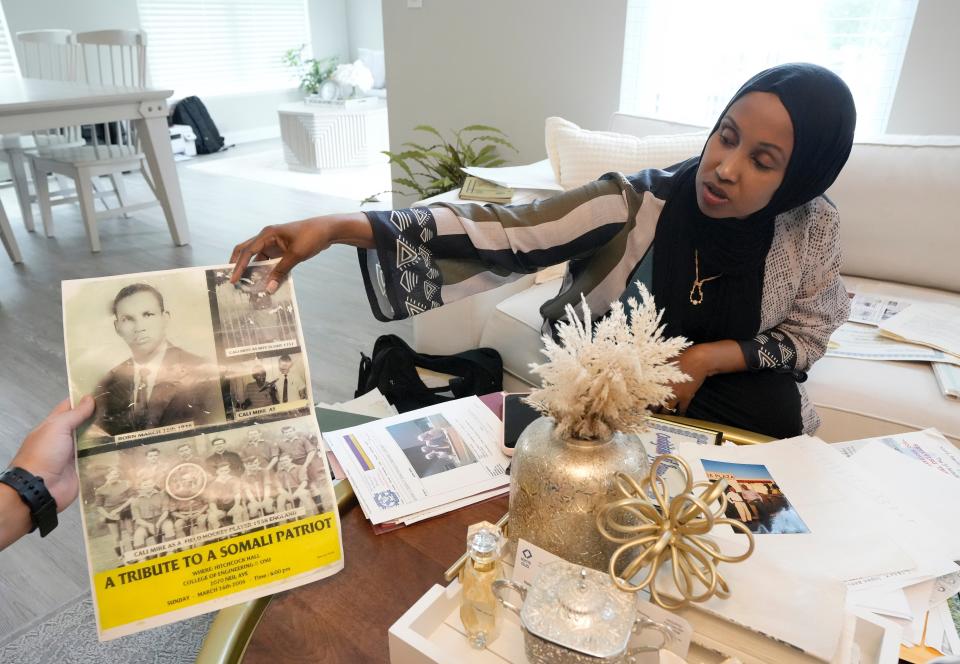 Ayana Mire shows off a flyer from a 2006 celebration of her father, Ali Mire Awaale, the composer of the Somali national anthem, on Wednesday in Columbus.