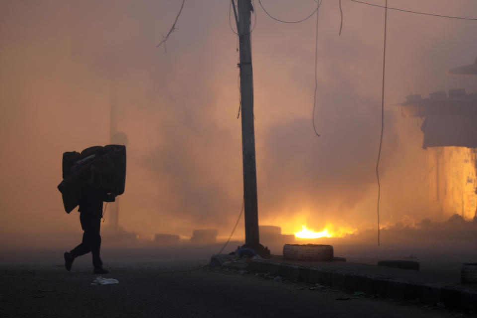 A Palestinian man carries his belongings while fleeing the Naser neighbourhood following Israeli airstrike on Gaza City, Wednesday, Nov. 8, 2023. (AP Photo/Abed Khaled)