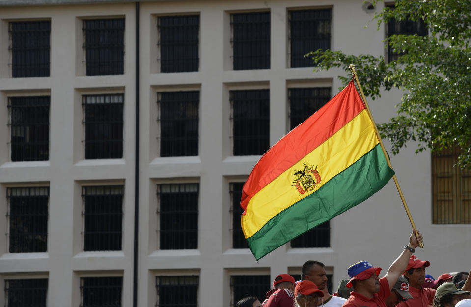 A pro-government supporter waves a Bolivian national flag during a rally in Caracas, Venezuela, Saturday, Nov. 16, 2019. Nicolas Maduro’s socialist party called its members to demonstrate in solidarity with Bolivia’s Evo Morales, who resigned the presidency and fled into exile in Mexico on Nov. 10, claiming a coup d’etat following massive protests accusing him of engineering a fraudulent reelection. (AP Photo/Matias Delacroix)