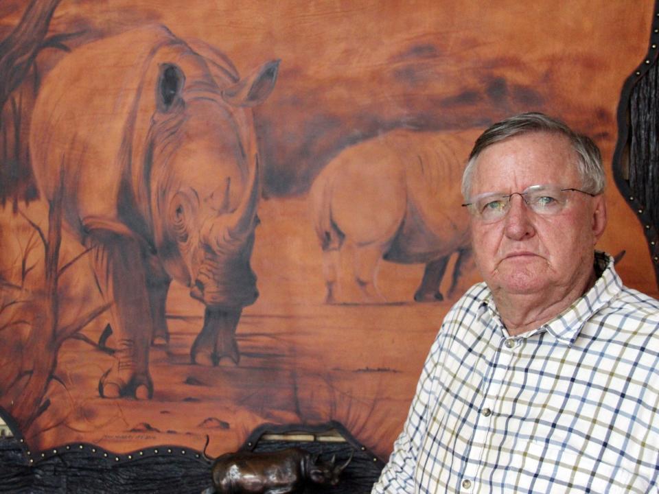 John Hume, owner of the private rhino breeding farm in South Africa, stands in front of a rhino painting in the office of his rhino breeding farm.