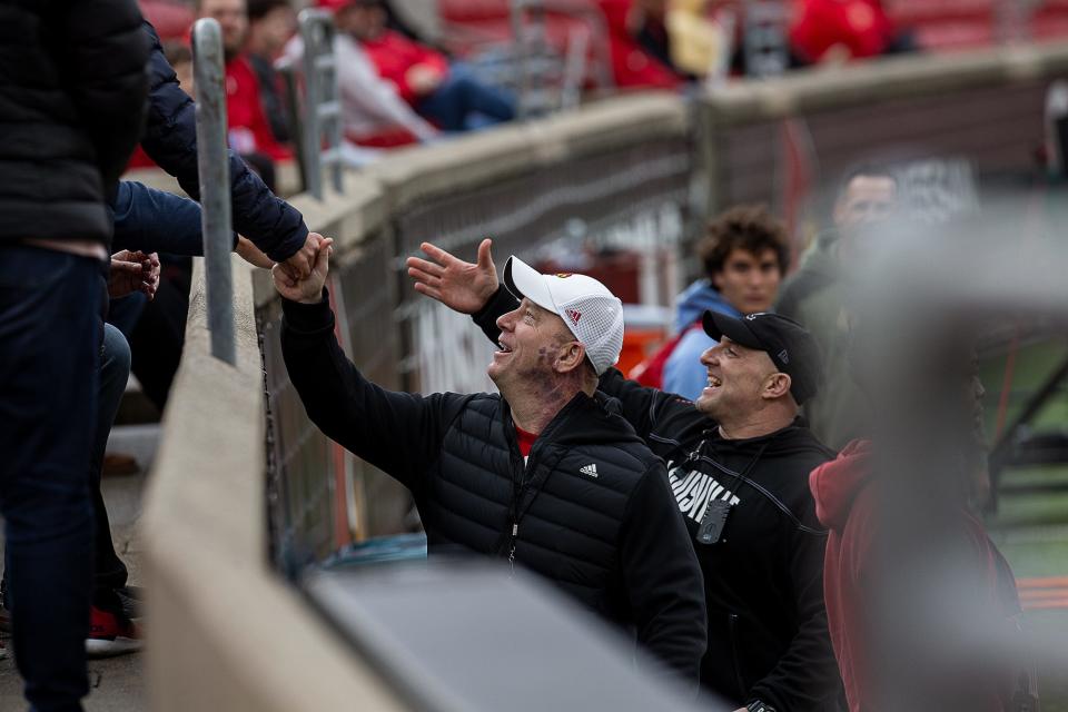 Louisville Cardinals head football coach Jeff Brohm greeted a family in the stands during practice at L&N Stadium on March 25, 2023.