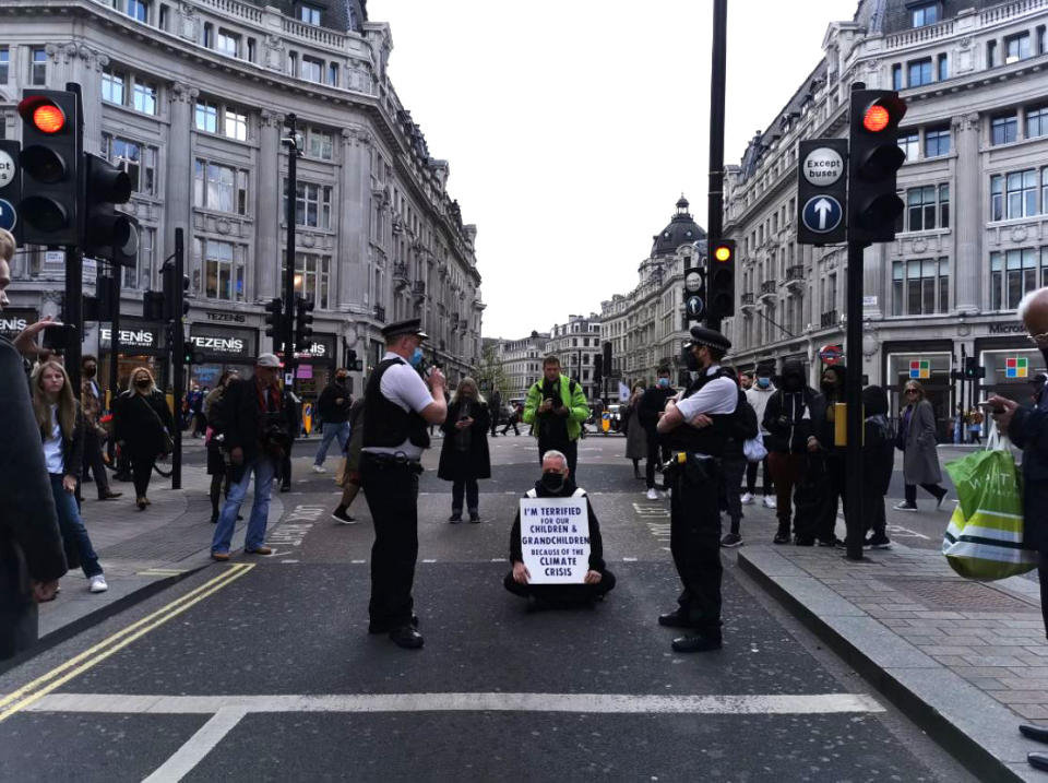 Handout photo taken with permission from the Twitter feed of @dantendles of a protester blocking traffic in Oxford Circus, London, as hundreds of people are staging 