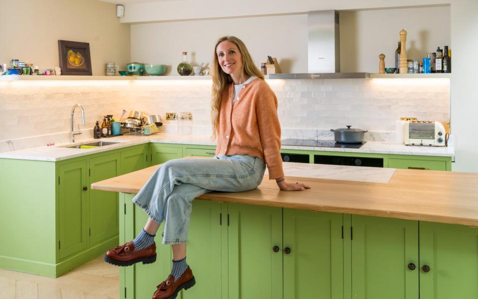 Anna Tyzack with her re-decorated kitchen cabinets, which were the cause of conflict between her and her husband