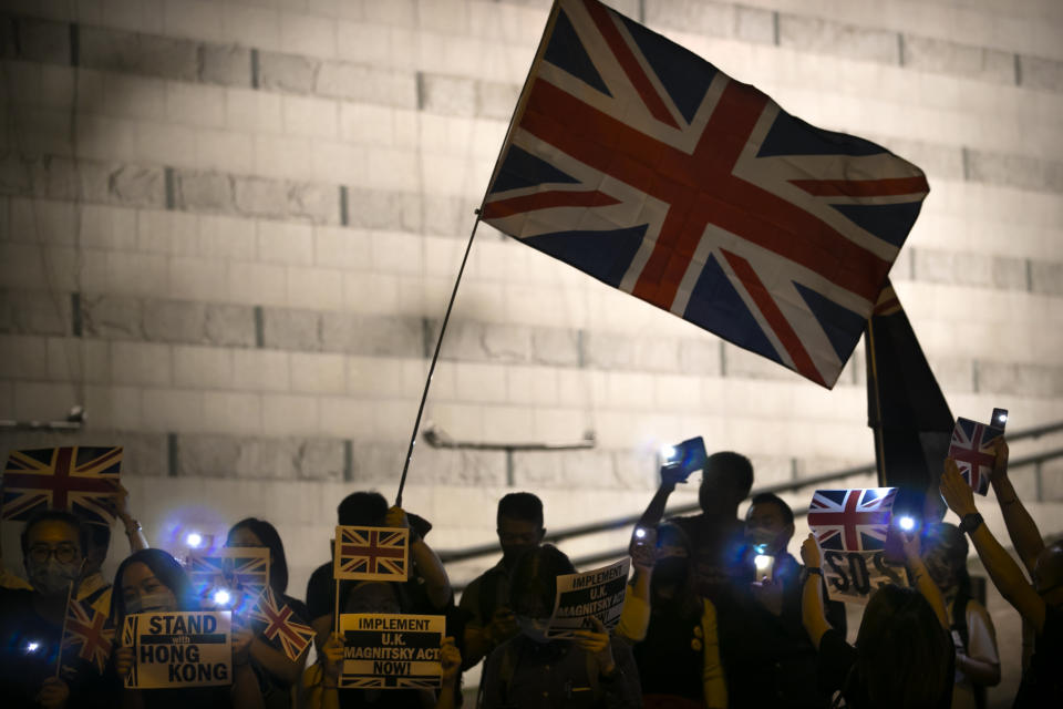 Demonstrators wave a British flag during a rally outside of the British Consulate in Hong Kong, Wednesday, Oct. 23, 2019. Some hundreds of Hong Kong pro-democracy demonstrators have formed a human chain at the British consulate to rally support for their cause from the city's former colonial ruler. (AP Photo/Mark Schiefelbein)