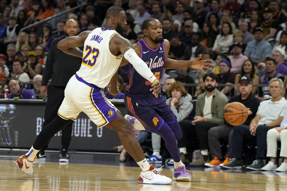 Los Angeles Lakers forward LeBron James (23) knocks the ball away from Phoenix Suns forward Kevin Durant, right, during the second half of an NBA basketball game, Sunday, Feb. 25, 2024, in Phoenix. (AP Photo/Rick Scuteri)